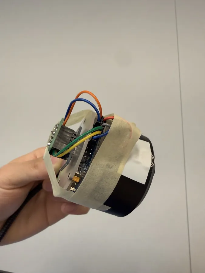 The audio board from the side, wires and tape around the speaker