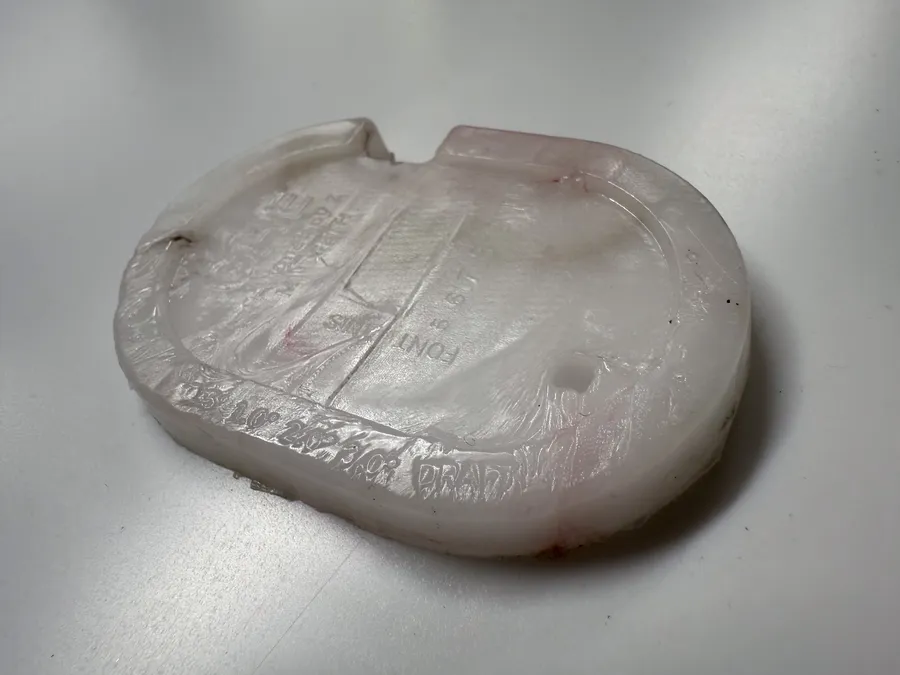 A white PP Gaugey test piece, lettering and ribs visible